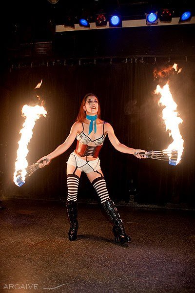 Fire dancer Seraphina holding two lit fire torches